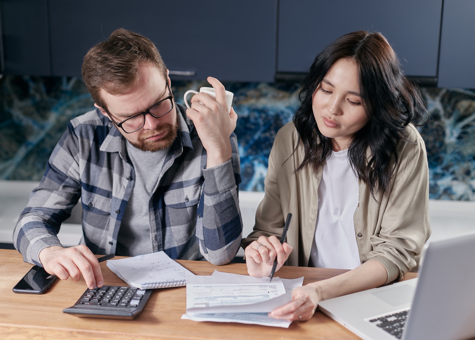 Professionals reviewing household finances while planning for critical illness financial preparedness.