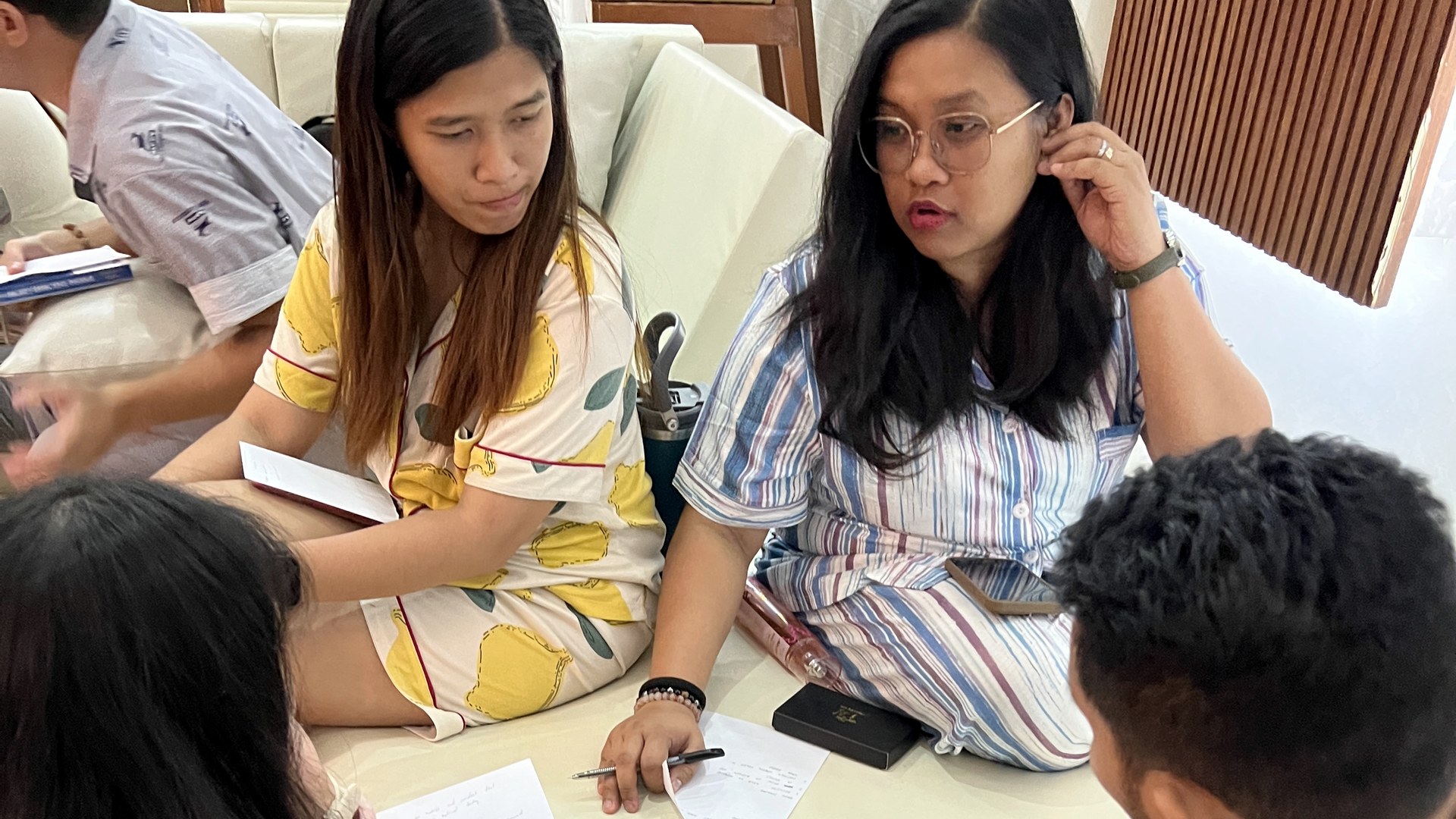 Professionals exchanging ideas and taking notes during a small-group learning session.